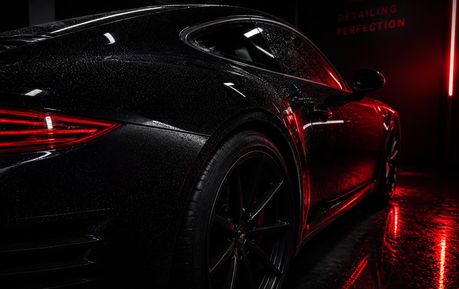 Carro preto com pintura vitrificada em estúdio de estética automotiva